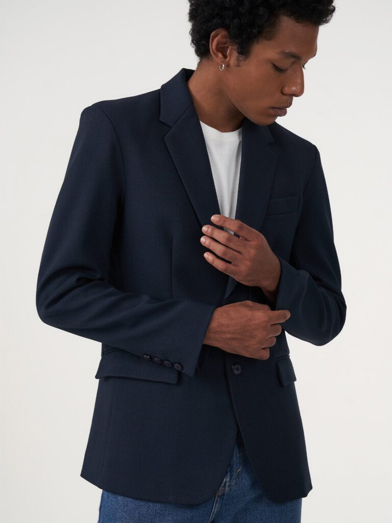 Blazer hitam di atas kemeja putih dengan jeans